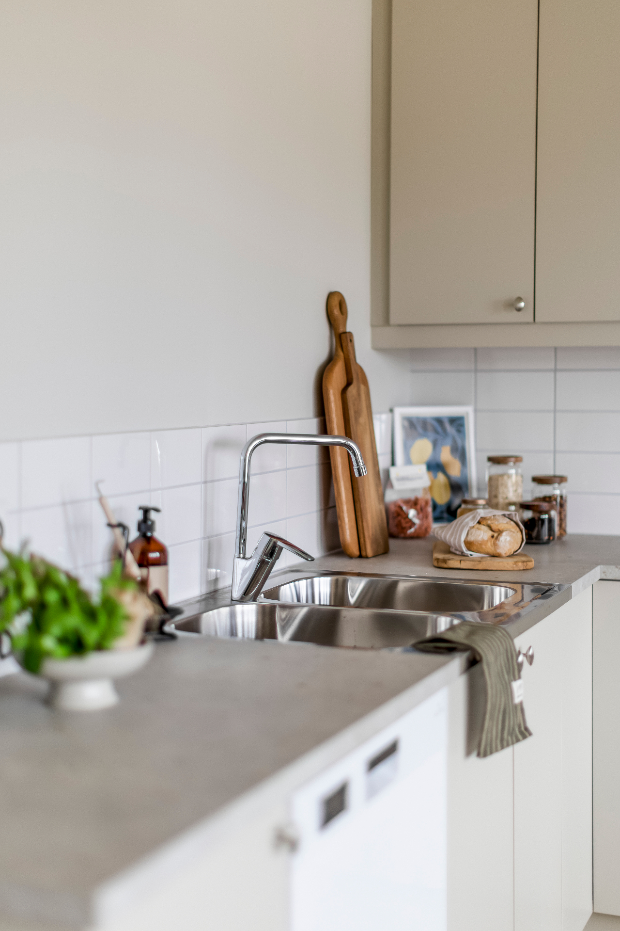 Köksdetalj med diskbänk, skärbrädor och örter
