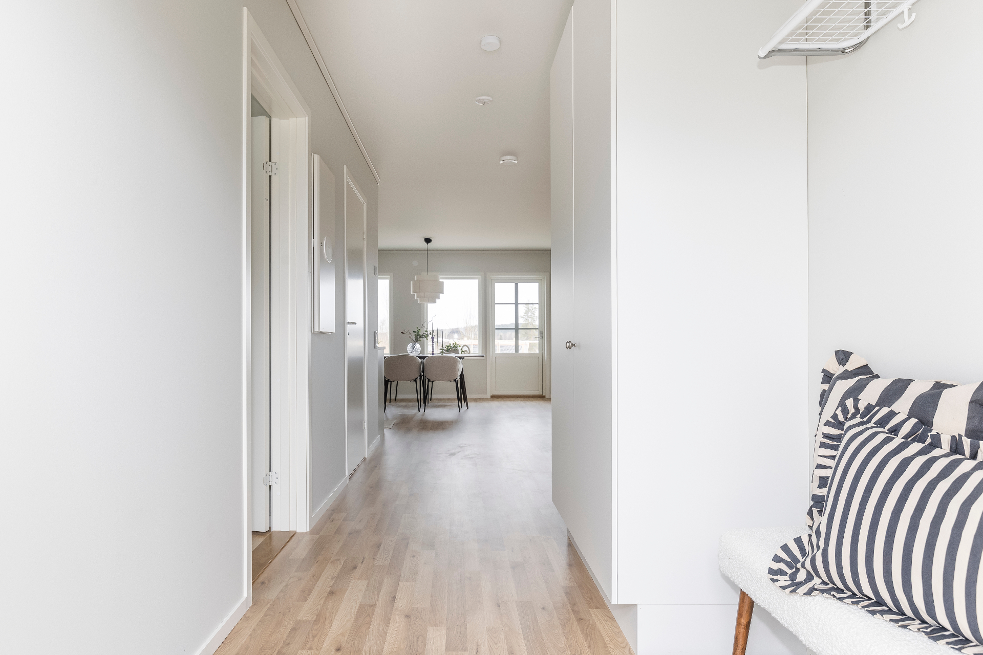 Hall med ekparkett som leder till matplats